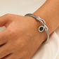 Vintageinspirerat armband med delikat spiralreptextur och hästskospänne